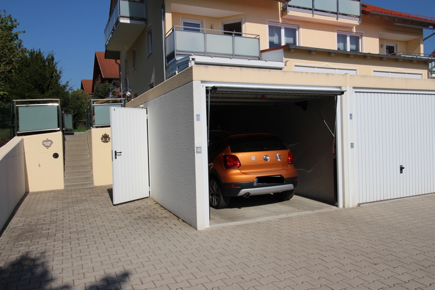 zur Wohnung gehört eine Garage und ein danebenliegender Kfz-Stellplatz