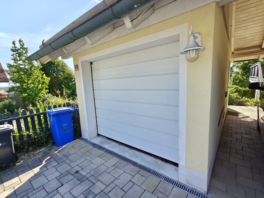 zum Haus gehört ein Garagenstellplatz sowie ein Carport